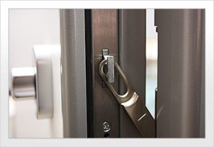 Eine Nahaufnahme eines Türriegels, der in ein Metallschließblech eingerastet ist und die Fenster- und Türensicherungen geschlossen hält.